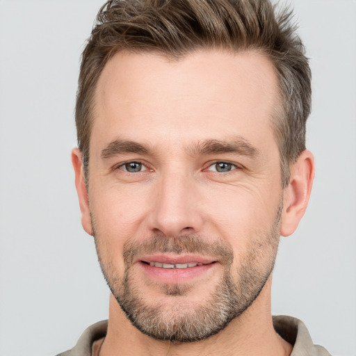 Joyful white young-adult male with short  brown hair and grey eyes