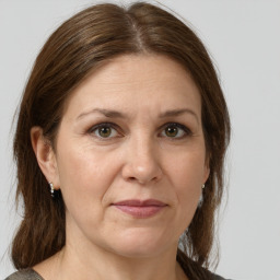 Joyful white adult female with medium  brown hair and green eyes