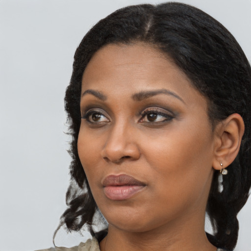 Joyful black young-adult female with long  black hair and brown eyes