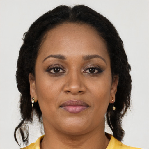 Joyful black adult female with long  brown hair and brown eyes