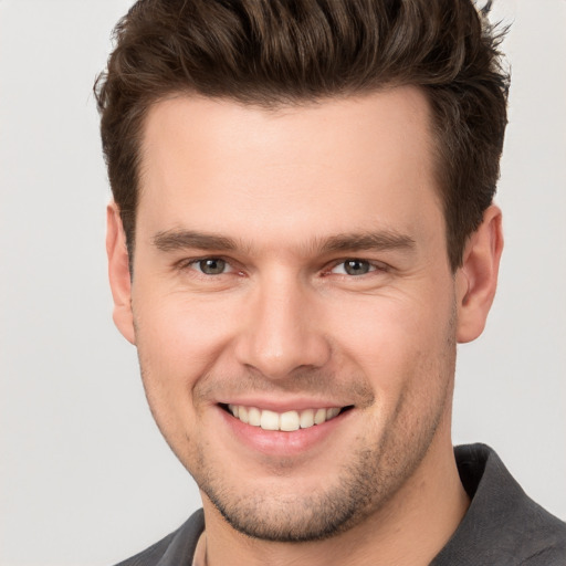 Joyful white young-adult male with short  brown hair and brown eyes