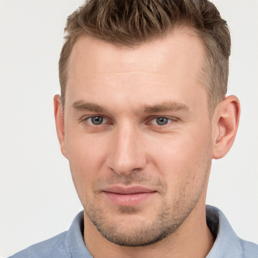 Joyful white young-adult male with short  brown hair and grey eyes