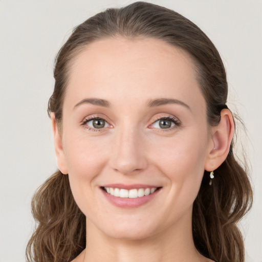 Joyful white young-adult female with long  brown hair and blue eyes