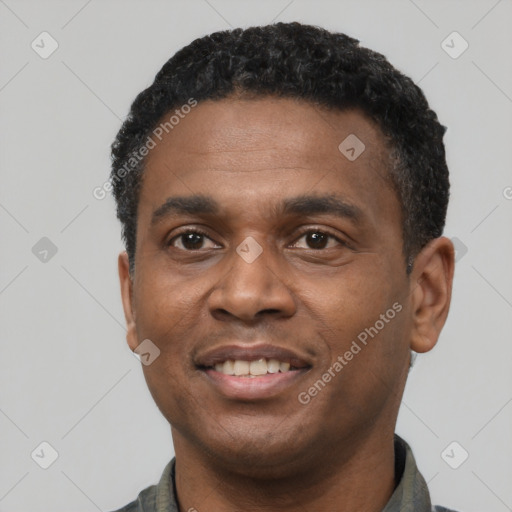 Joyful black young-adult male with short  black hair and brown eyes
