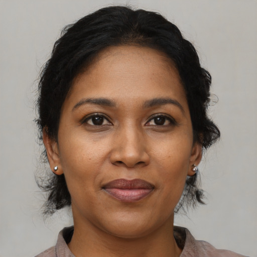 Joyful black adult female with medium  brown hair and brown eyes