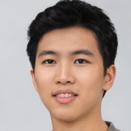 Joyful asian young-adult male with short  black hair and brown eyes