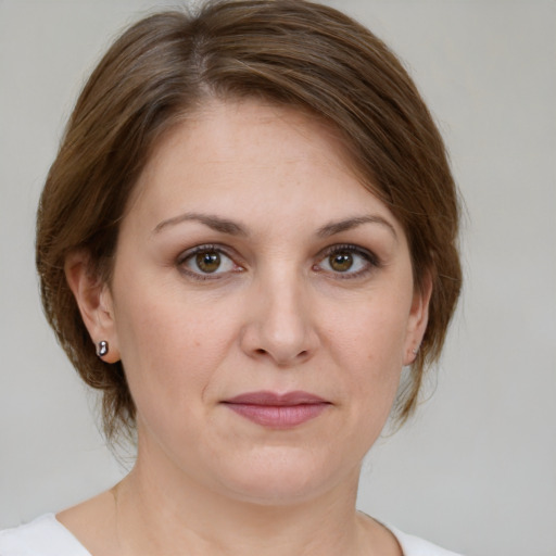 Joyful white young-adult female with medium  brown hair and green eyes