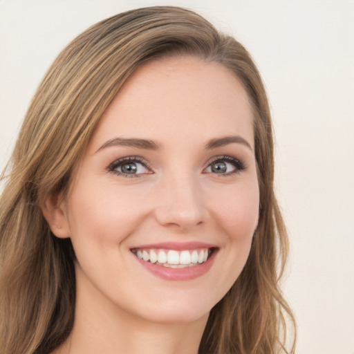 Joyful white young-adult female with long  brown hair and green eyes