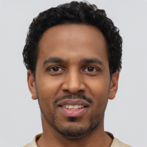 Joyful black young-adult male with short  black hair and brown eyes