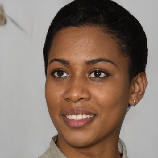 Joyful black young-adult female with short  black hair and brown eyes