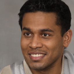 Joyful latino young-adult male with short  black hair and brown eyes