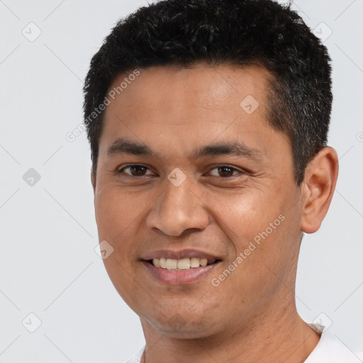 Joyful latino young-adult male with short  black hair and brown eyes