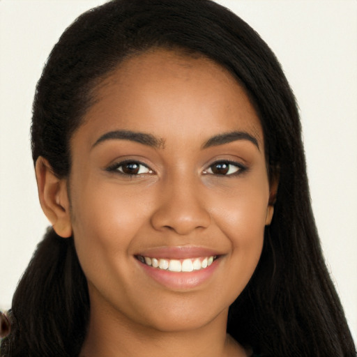 Joyful black young-adult female with long  brown hair and brown eyes