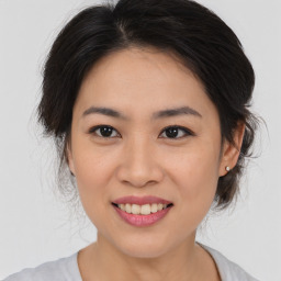 Joyful asian young-adult female with medium  brown hair and brown eyes