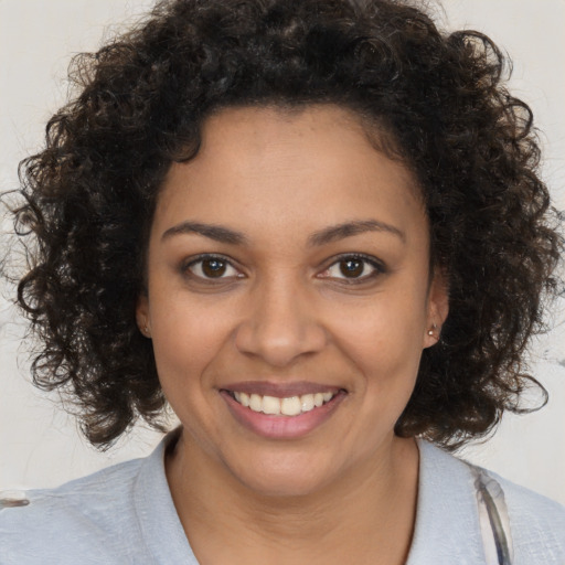 Joyful black young-adult female with medium  brown hair and brown eyes