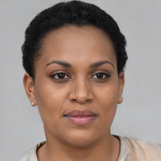 Joyful black young-adult female with short  black hair and brown eyes