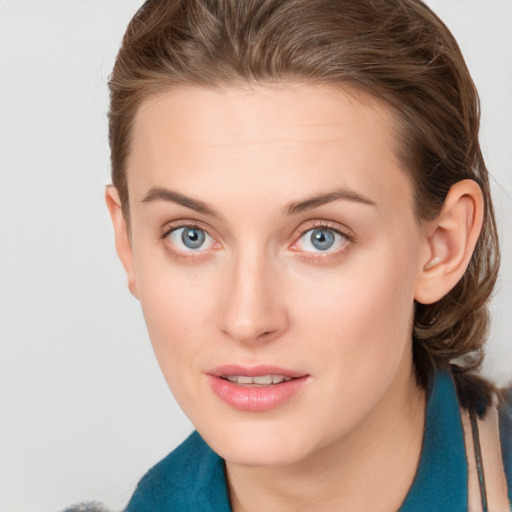 Joyful white young-adult female with short  brown hair and blue eyes