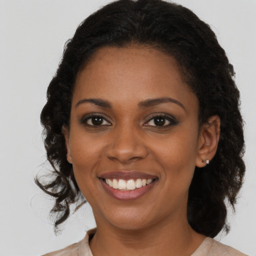 Joyful black young-adult female with medium  brown hair and brown eyes