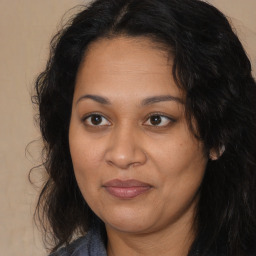 Joyful latino adult female with long  brown hair and brown eyes