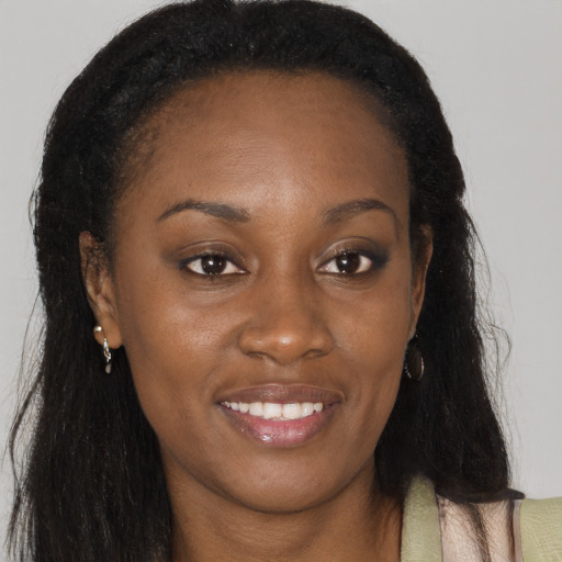 Joyful black young-adult female with long  brown hair and brown eyes