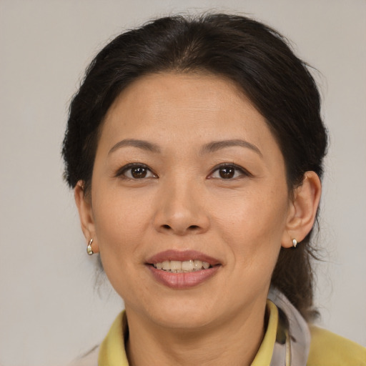 Joyful latino adult female with medium  brown hair and brown eyes