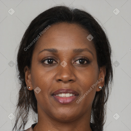 Joyful black adult female with long  brown hair and brown eyes