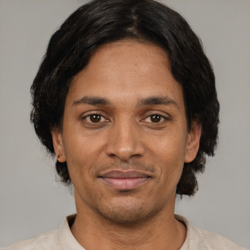 Joyful black adult male with short  brown hair and brown eyes