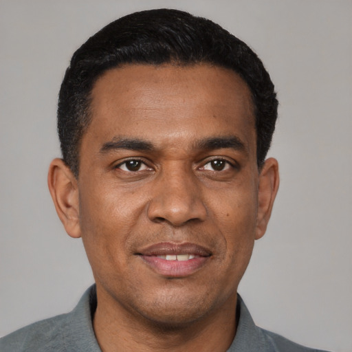 Joyful black young-adult male with short  black hair and brown eyes