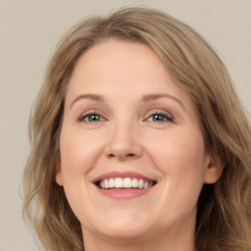 Joyful white adult female with long  brown hair and green eyes