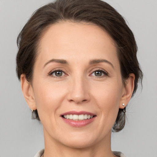 Joyful white adult female with medium  brown hair and grey eyes