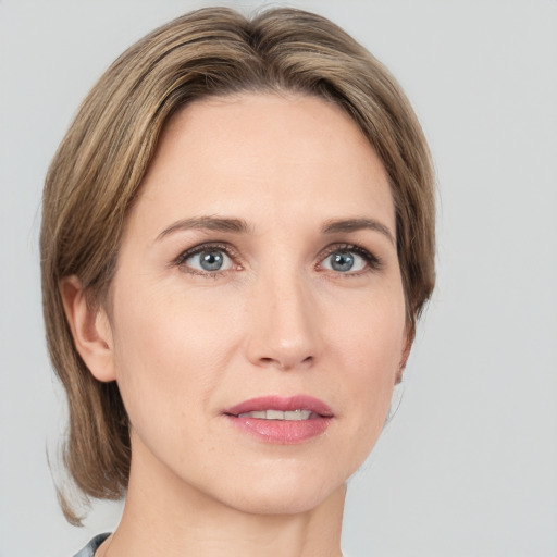 Joyful white adult female with medium  brown hair and grey eyes