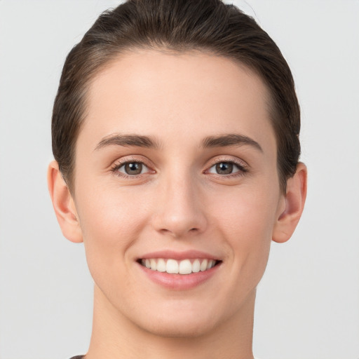 Joyful white young-adult female with short  brown hair and brown eyes