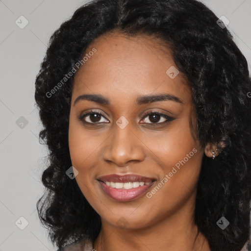 Joyful black young-adult female with long  black hair and brown eyes