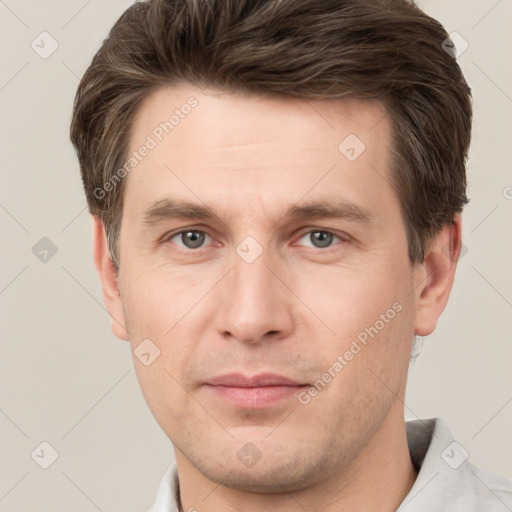 Joyful white young-adult male with short  brown hair and grey eyes