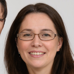 Joyful white adult female with long  brown hair and brown eyes