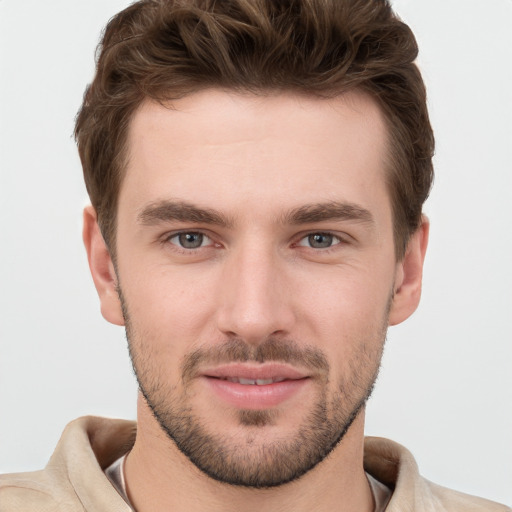 Joyful white young-adult male with short  brown hair and grey eyes