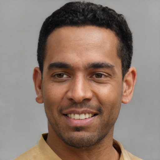 Joyful latino young-adult male with short  black hair and brown eyes