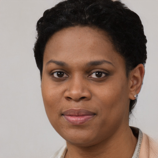 Joyful black young-adult female with short  black hair and brown eyes