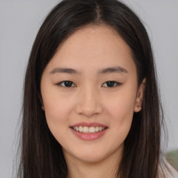 Joyful asian young-adult female with long  brown hair and brown eyes