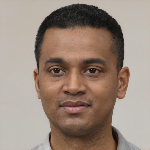 Joyful black young-adult male with short  black hair and brown eyes