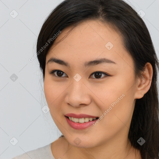 Joyful asian young-adult female with long  brown hair and brown eyes