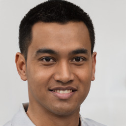 Joyful latino young-adult male with short  black hair and brown eyes