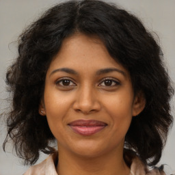 Joyful black young-adult female with medium  brown hair and brown eyes