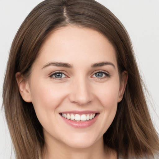 Joyful white young-adult female with long  brown hair and grey eyes