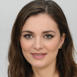 Joyful white young-adult female with long  brown hair and green eyes