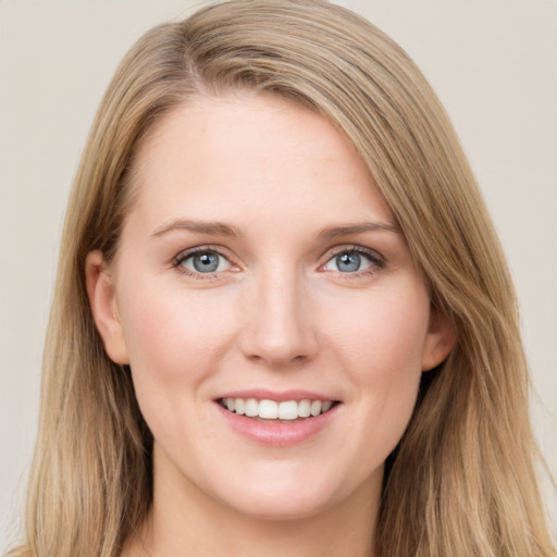 Joyful white young-adult female with long  brown hair and blue eyes