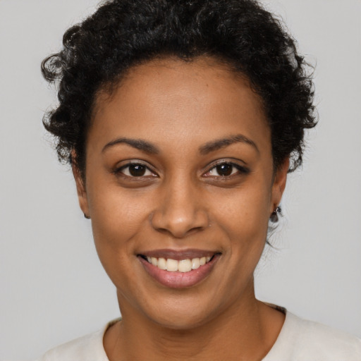 Joyful black young-adult female with short  brown hair and brown eyes