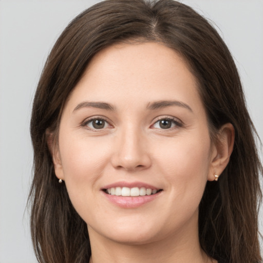 Joyful white young-adult female with long  brown hair and brown eyes