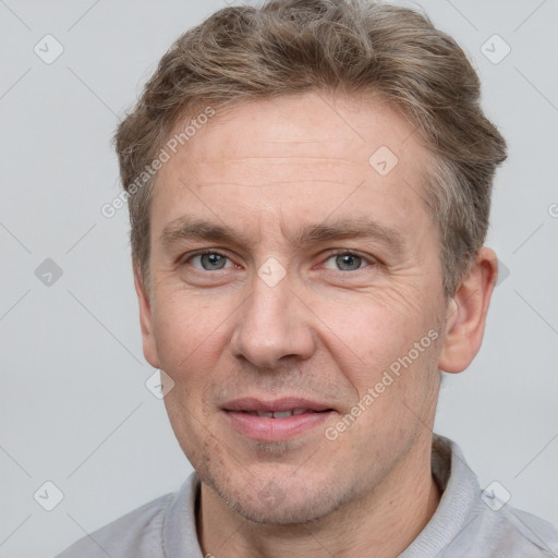 Joyful white adult male with short  brown hair and grey eyes