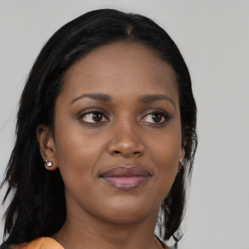 Joyful black young-adult female with long  brown hair and brown eyes